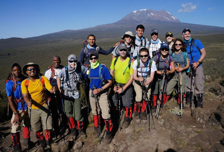 A group of students posing for a photo while hiking a mountain. 