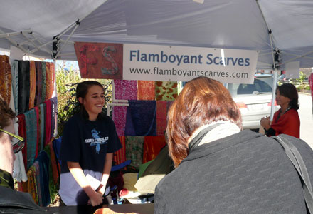 Ryan Katherine McCord laughs as she talks to a customer under a canopy where McFord is selling her Flamboyant Scarves. 