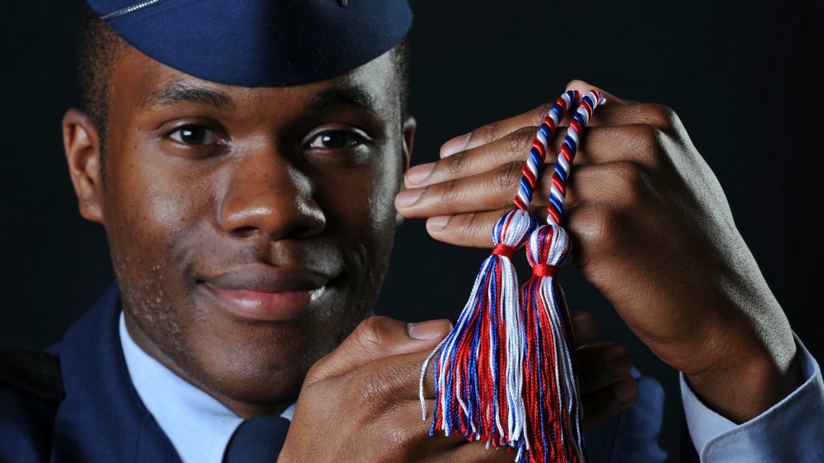 Micah Poulson holds his military honor cords.