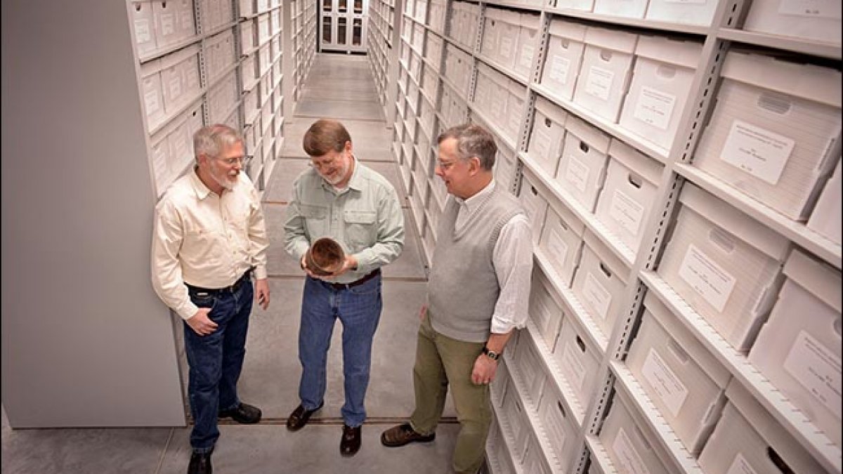 Brett Riggs, Steve Davis and Vin Steponatis stand in the North Carolina Archaeological Collection.