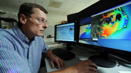 Dr. Rick Leuttich, director of the UNC Center for Natural Hazards and Disasters, sits at his computer to use modeling to predict storm surge from hurricanes and the areas affected