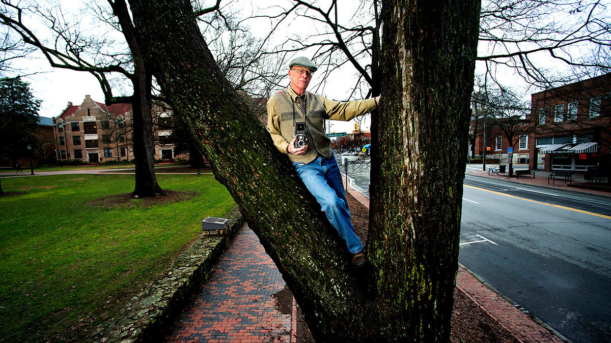 Jock Lauterer stands in a tree he took a photo from decades ago.