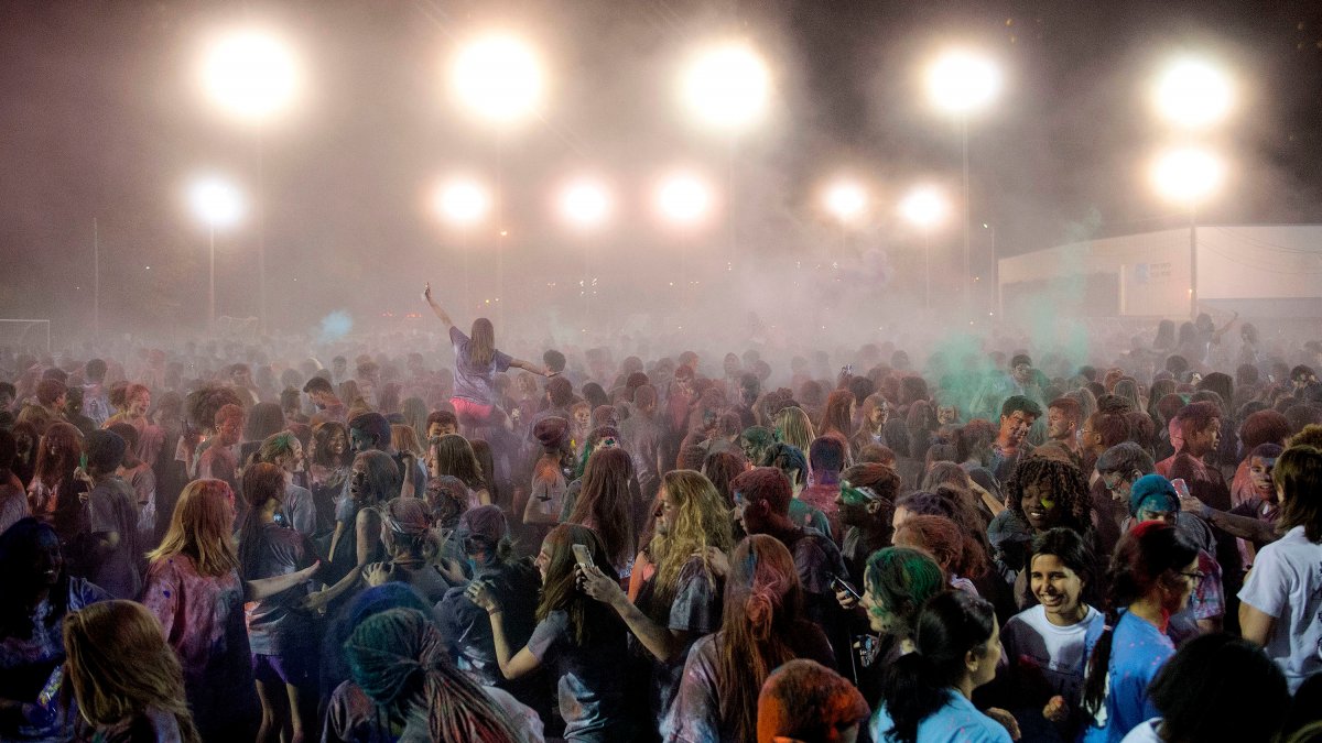 People dance covered in colorful dust.