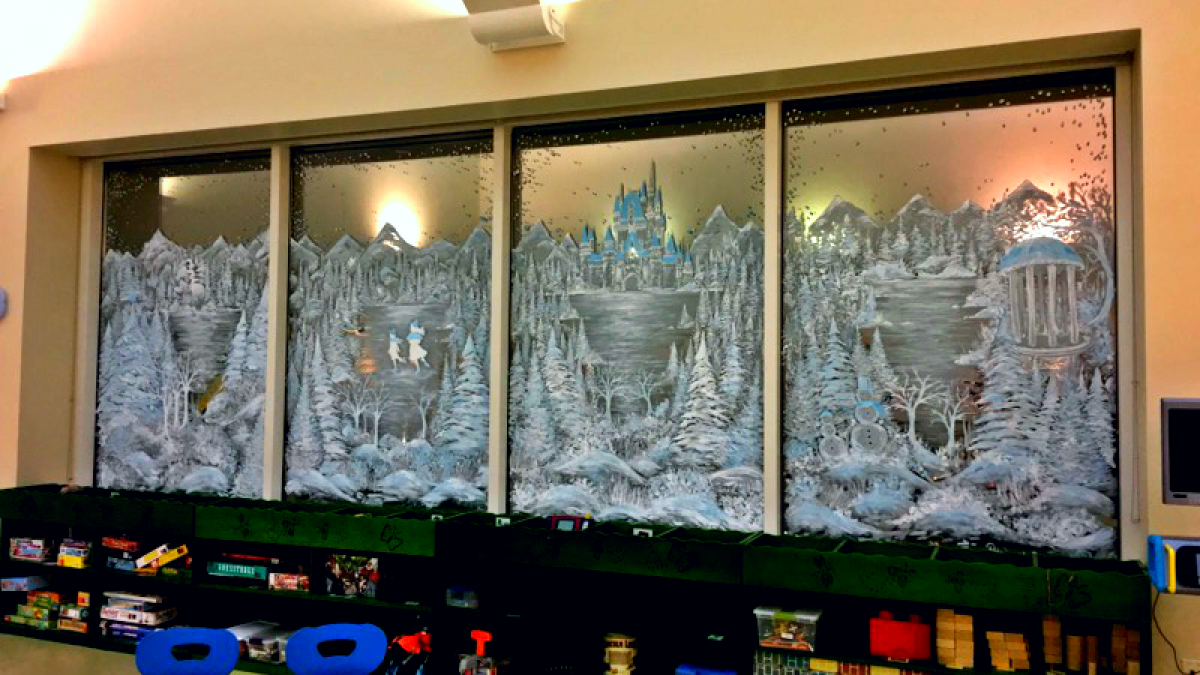 A window is painted with a winter scene.