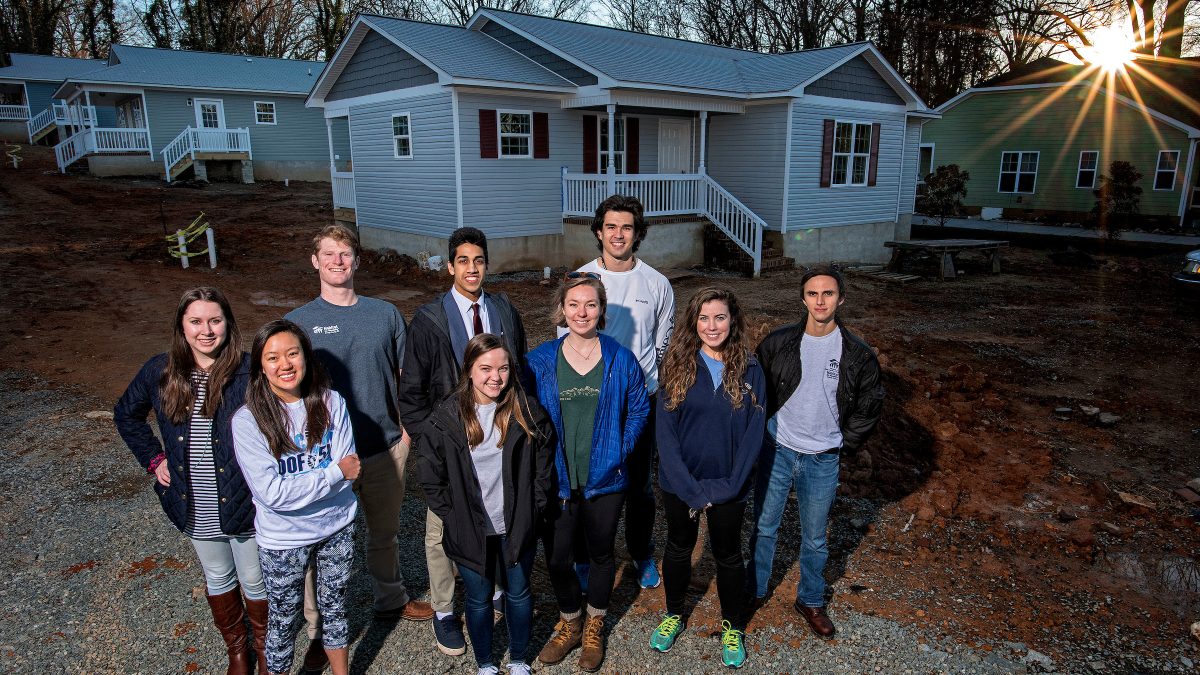 Group stands in front of a recently built house.