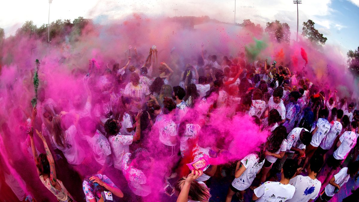 Color powder rains down of a group of people.