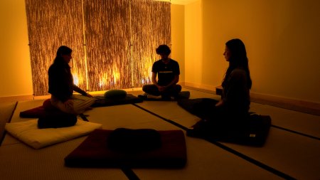 Three students sit on cushions in the meditation room in the Student Union.