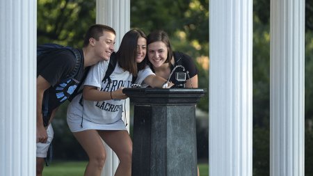 Students take photo by Old Well