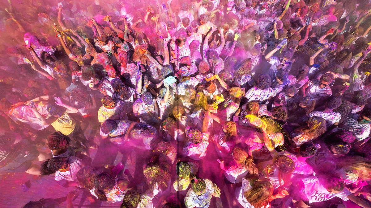 Students throw colorful powder in the air.