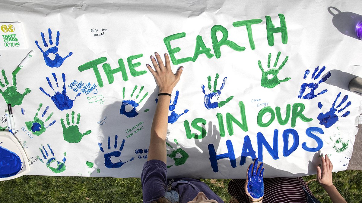 Students put hand prints on a paper banner