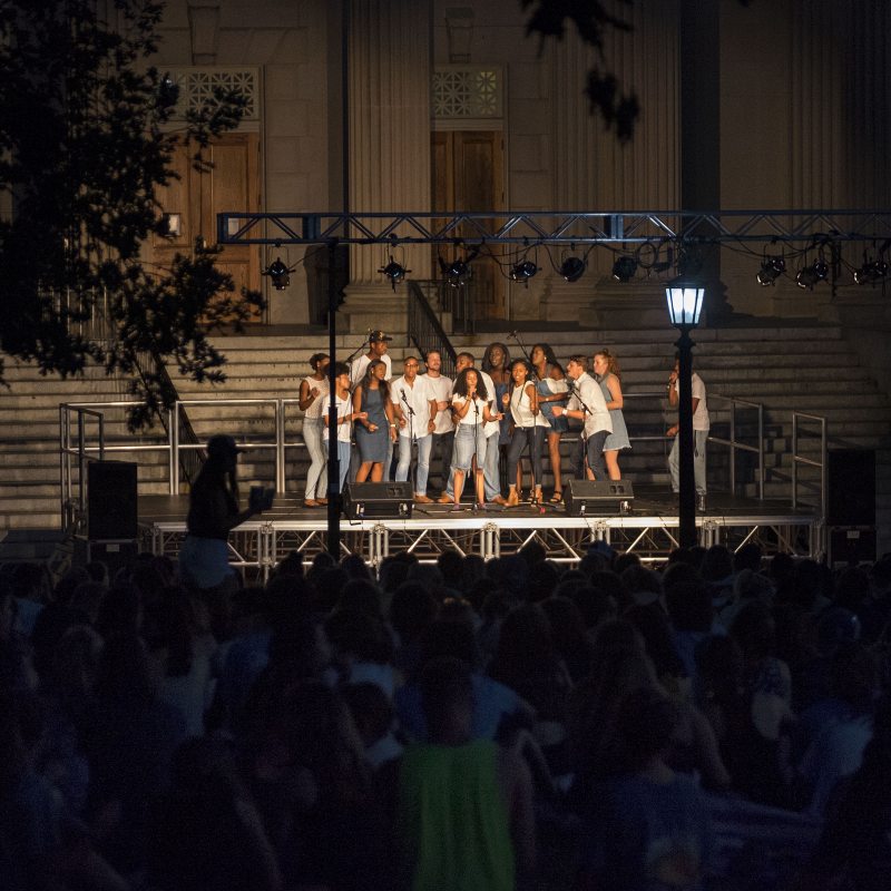 A cappella groups sing on stage during Sunset Serenade.