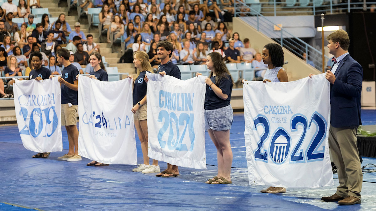 Students hold class flags during New Student Convocation.