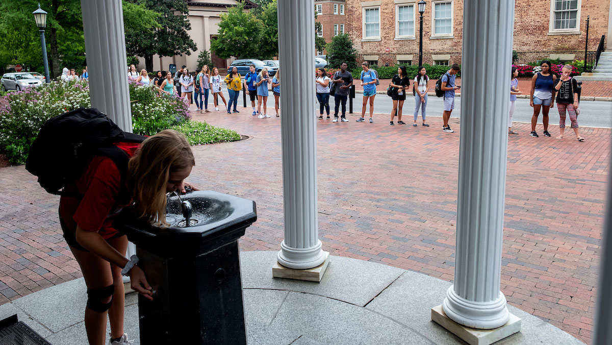 A student drinks from the Old Well.