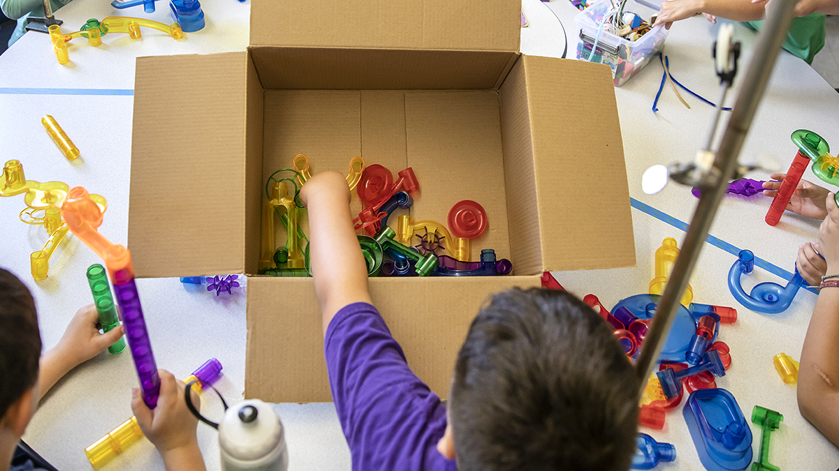Child take toys out of a cardboard box.