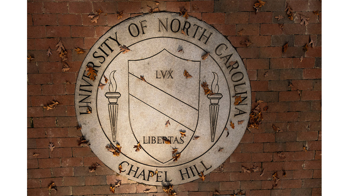 The University of North Carolina at Chapel Hill seal with fall leaves on top.
