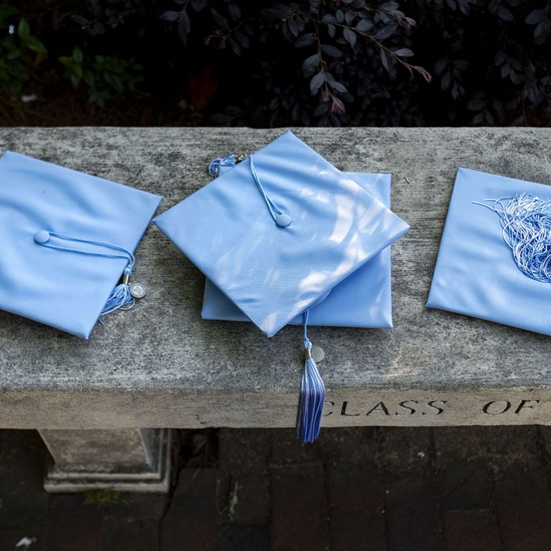 graduation caps on a bench.