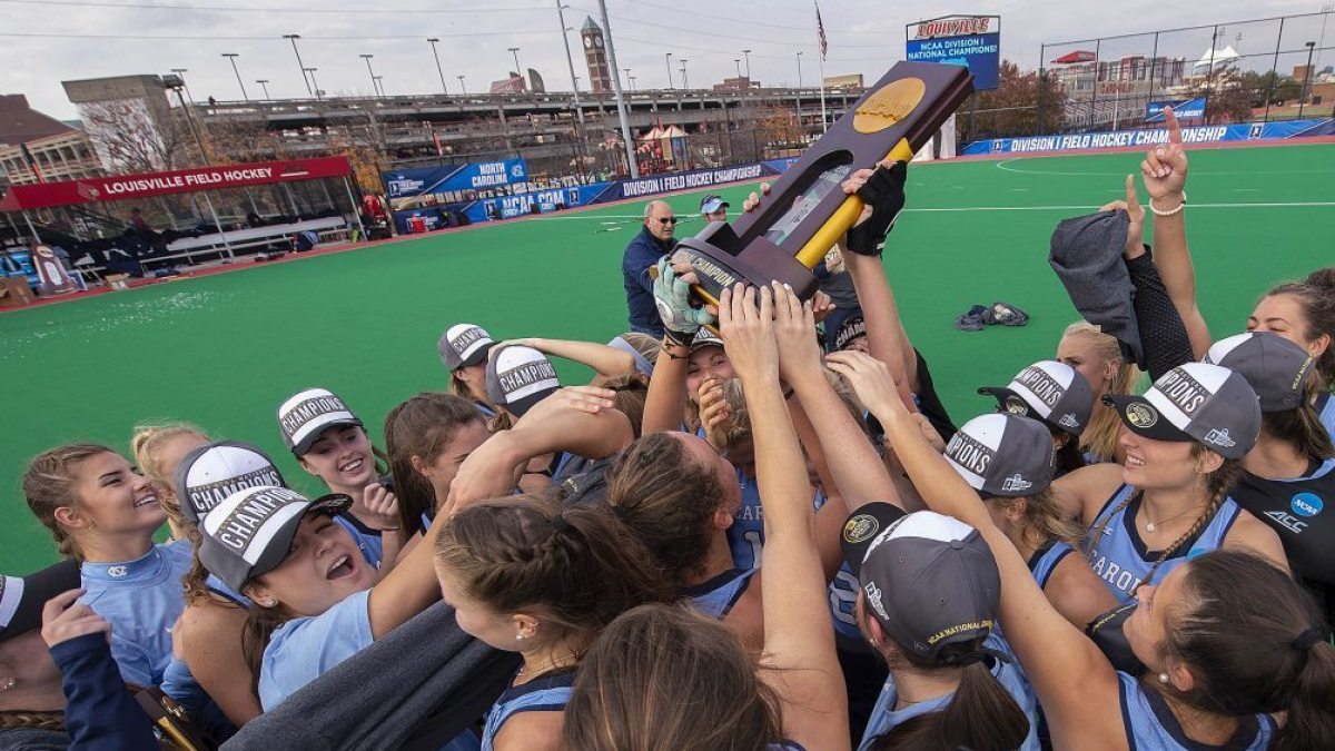 A UNC field hockey team lifts the national championship trophy.