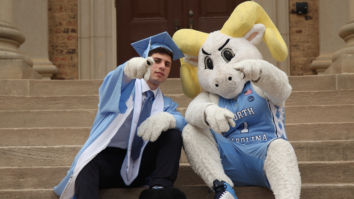 Alex Floch sits on the steps of South Building with Rameses.