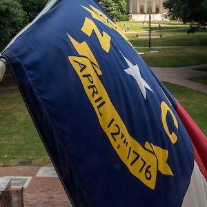 A North Carolina flag flies on South Building.