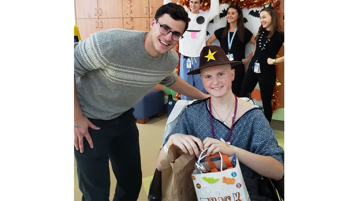 Carolina senior Eric Takoushian poses with Jake, who wears an Indiana Jones hat and carries a trick-or-treat bag
