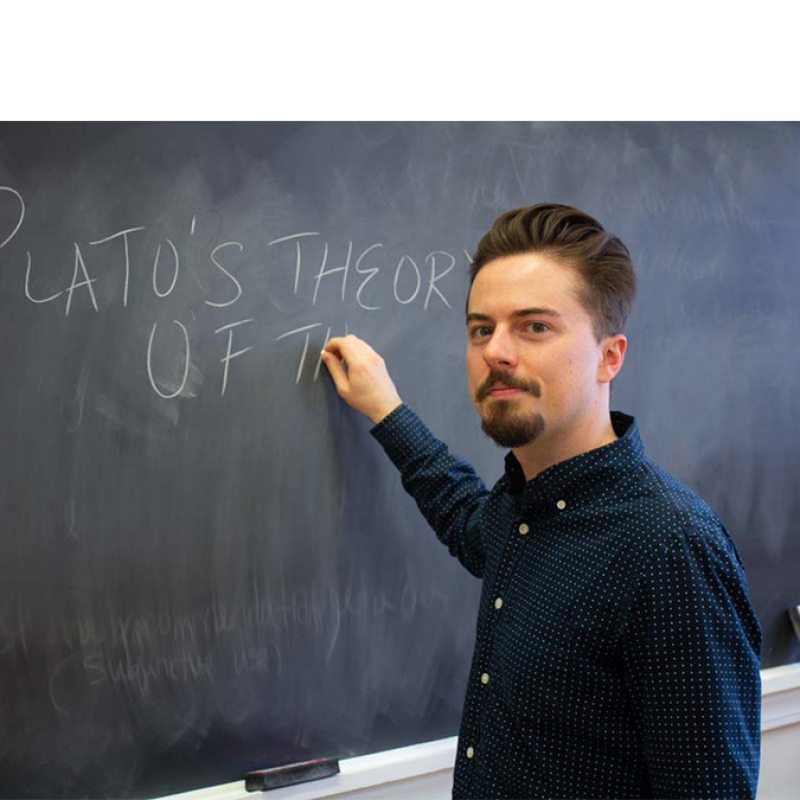 Philip Bold writing on chalkboard