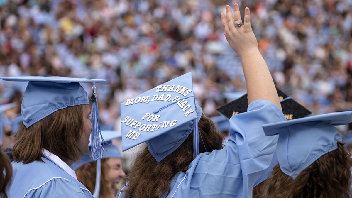 A student waves during Commencement.