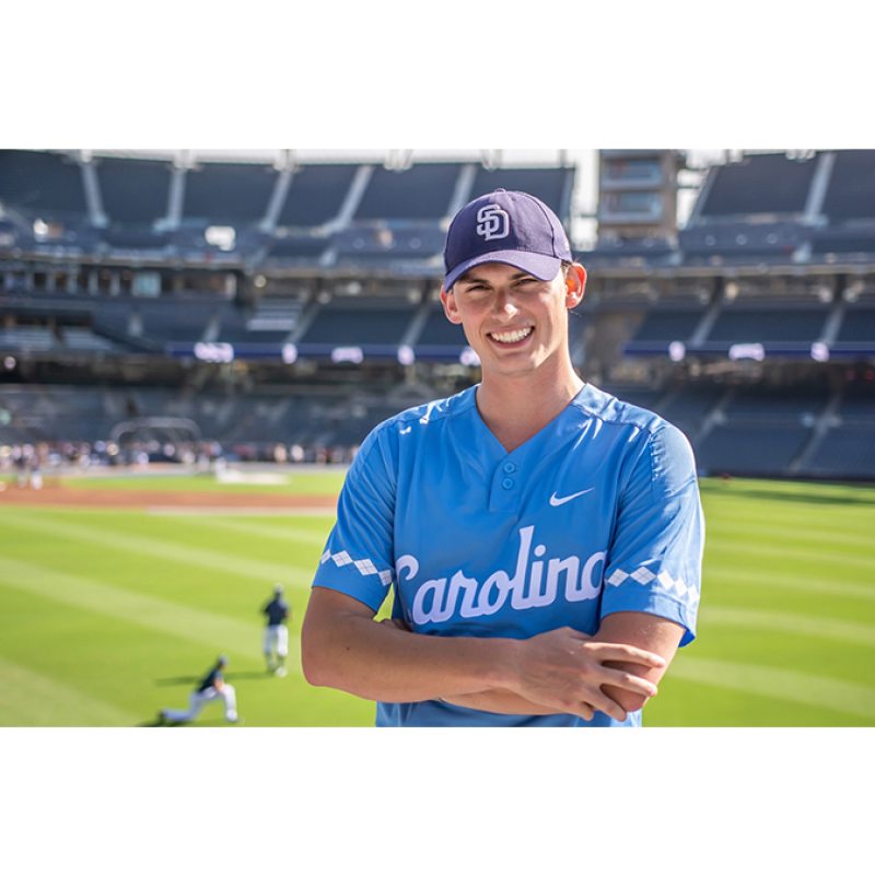 Blake Morgana wears a Carolina jersey and poses in front of the Padres' baseball park