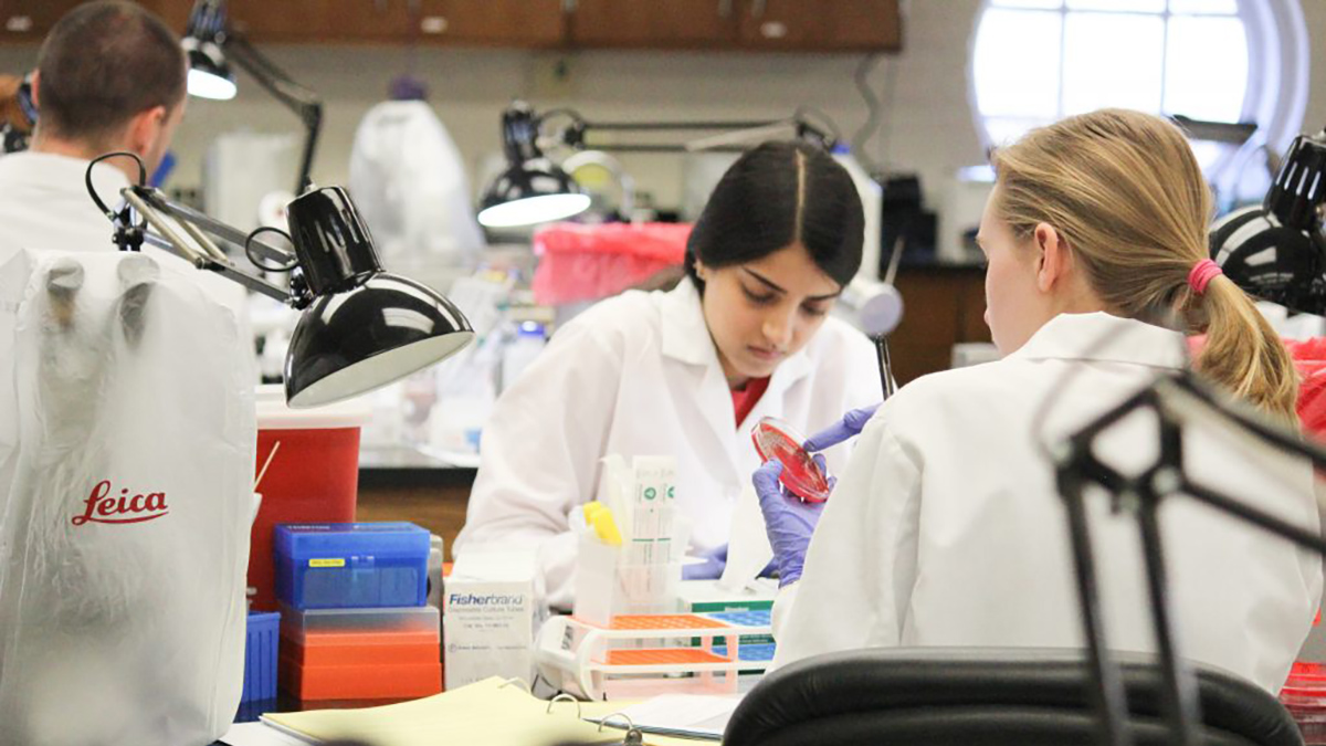 Two female students work in a science lab.