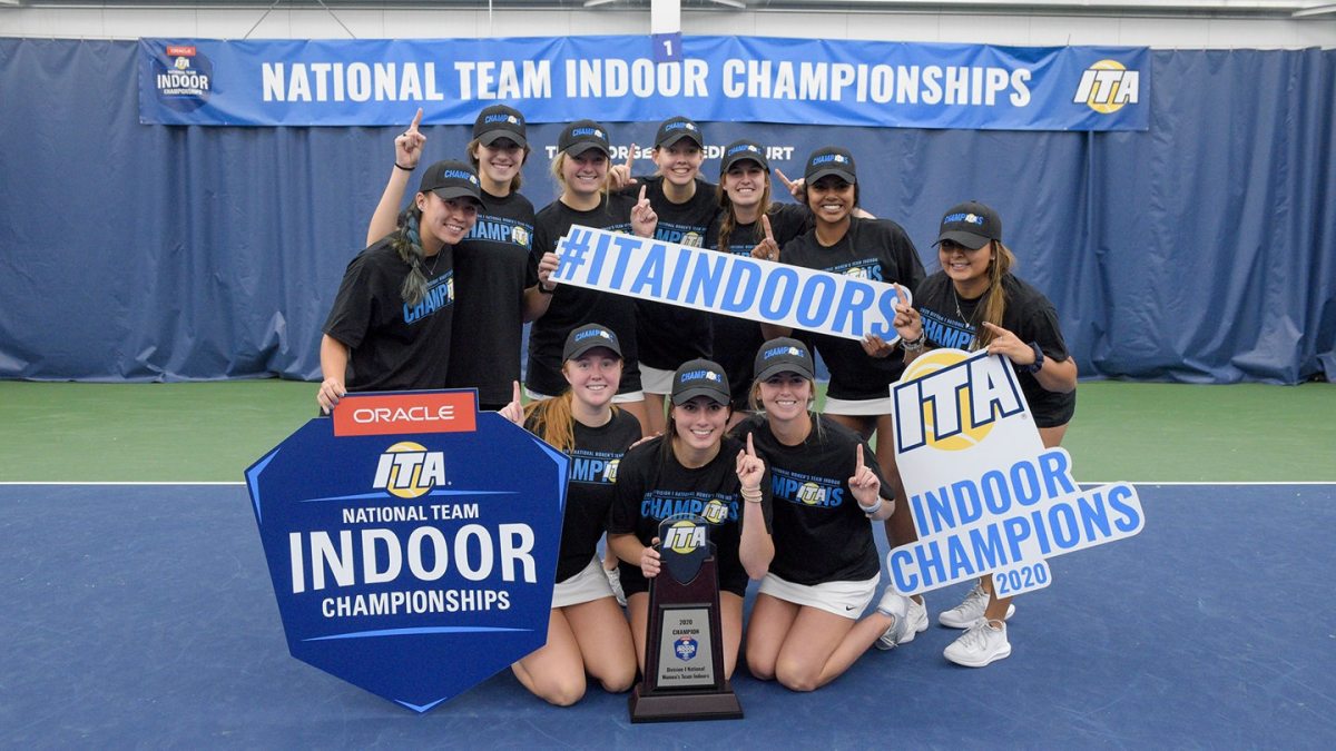 The women's tennis team holds of championship signs.