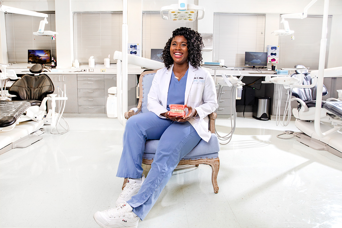 A woman sits in a chair in a dental office. 