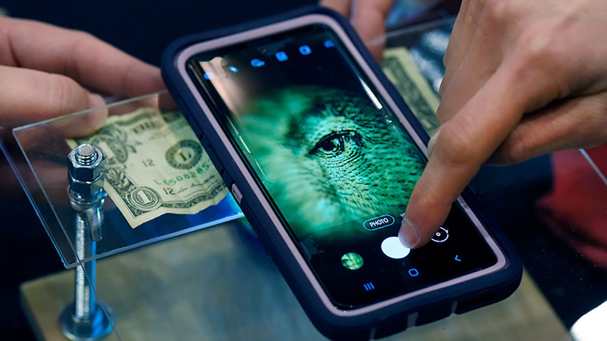 An iPhone is used as a microscope to examine a dollar bill.