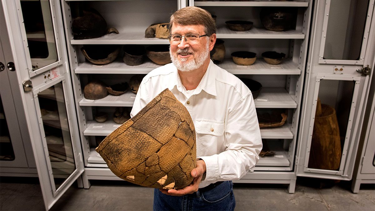 Massey Award winner Steve Davis holds a Native American artifact.