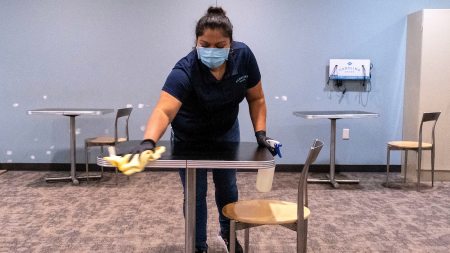 A woman cleans a table at the Union.