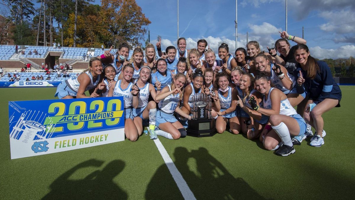 The Field hockey team celebrates with a 2020 championship banner.