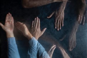 Many hands move across a dark background.