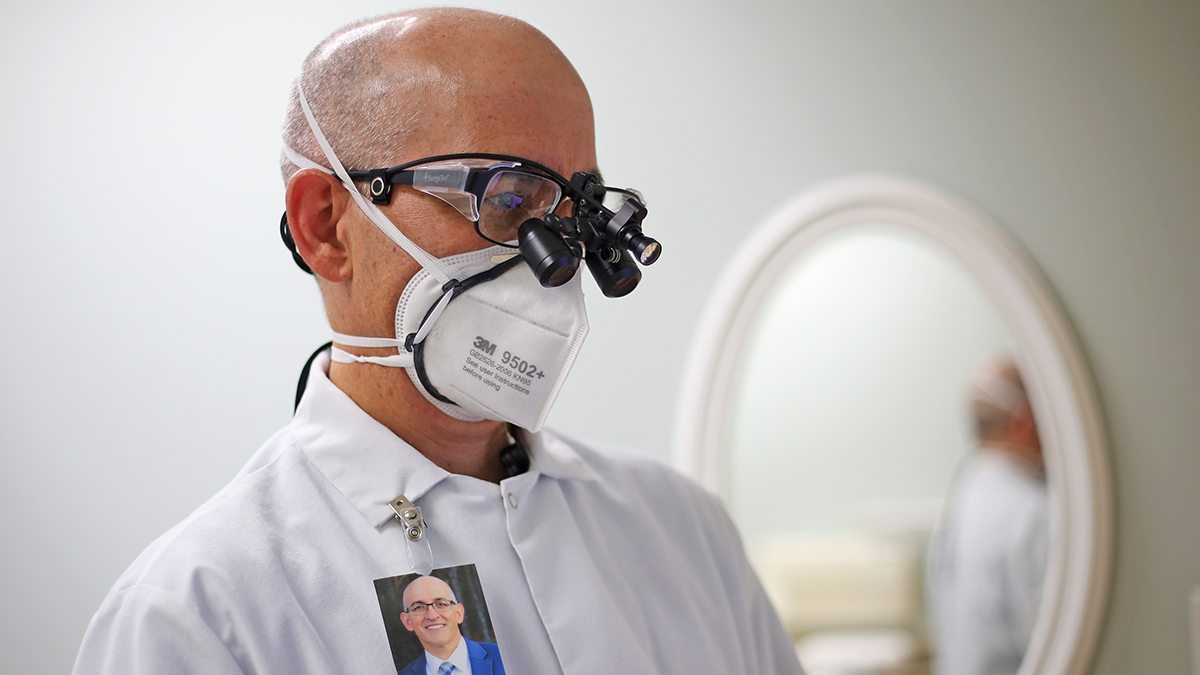 A dentist wears the AerFrame over his N95 mask.