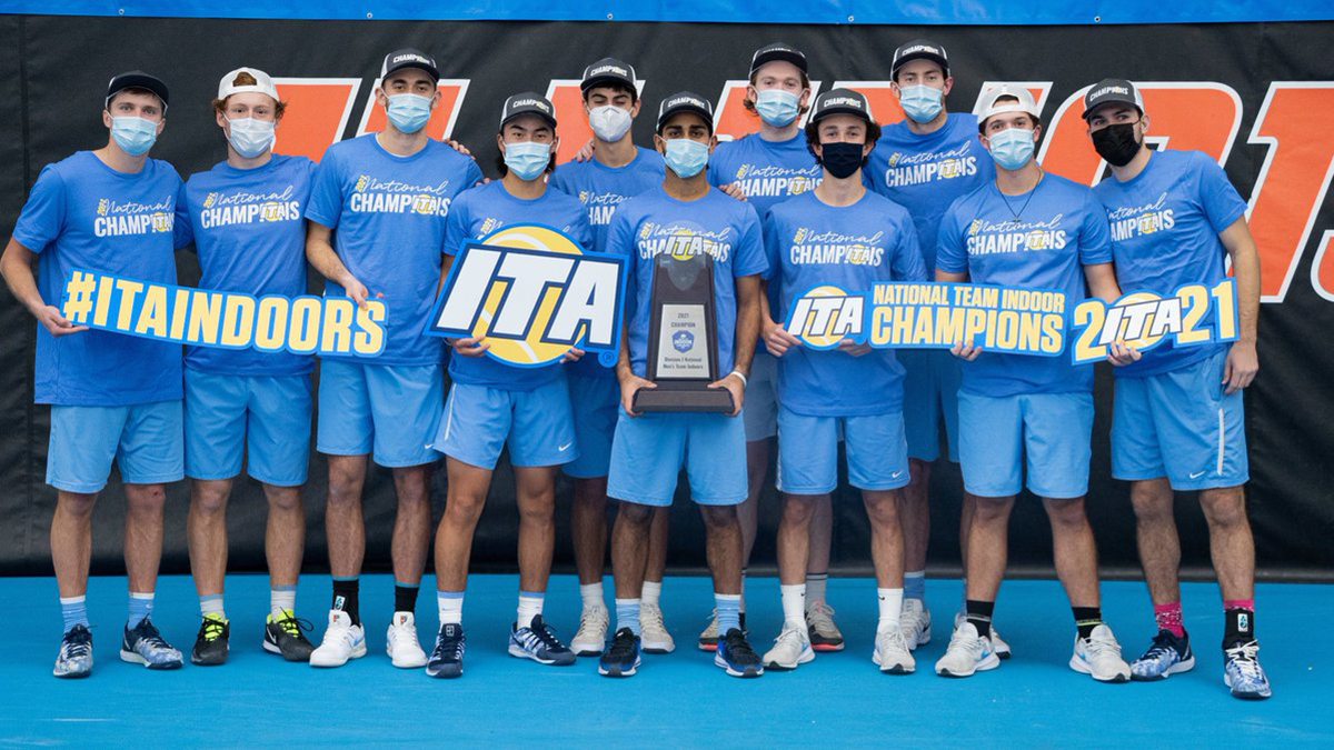 Members of the men's tennis team hold a ITA trophy.