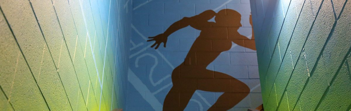 A mural of a person running in a stairwell.