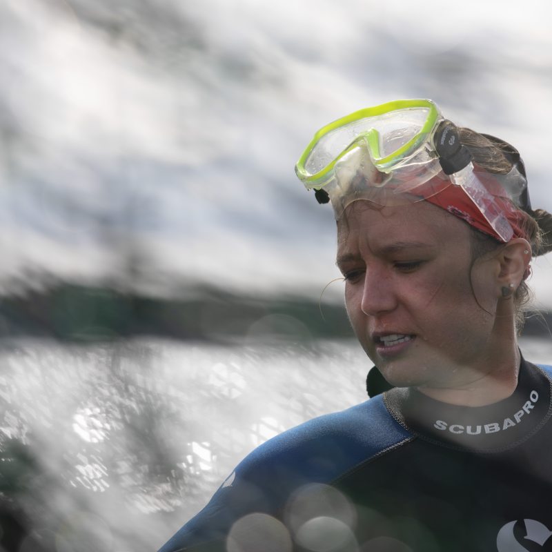 A woman in snorkling gear stands in the water.
