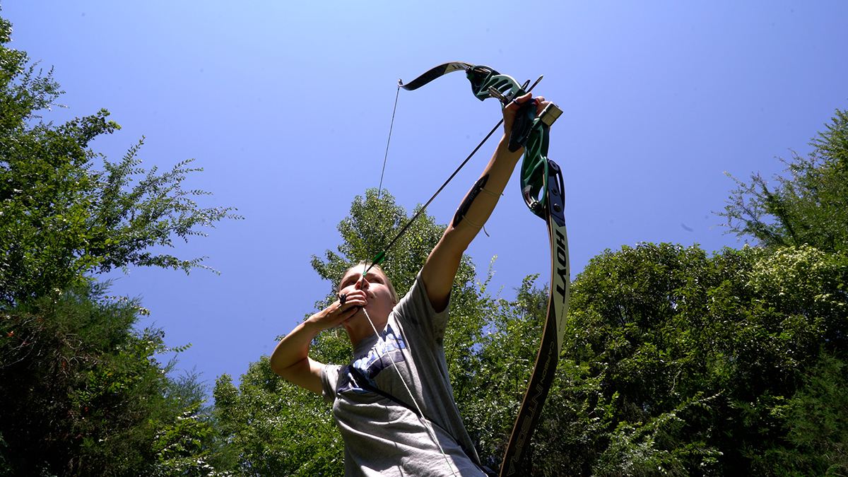 Laura Hughes pulls back on a bow to shoot an arrow.