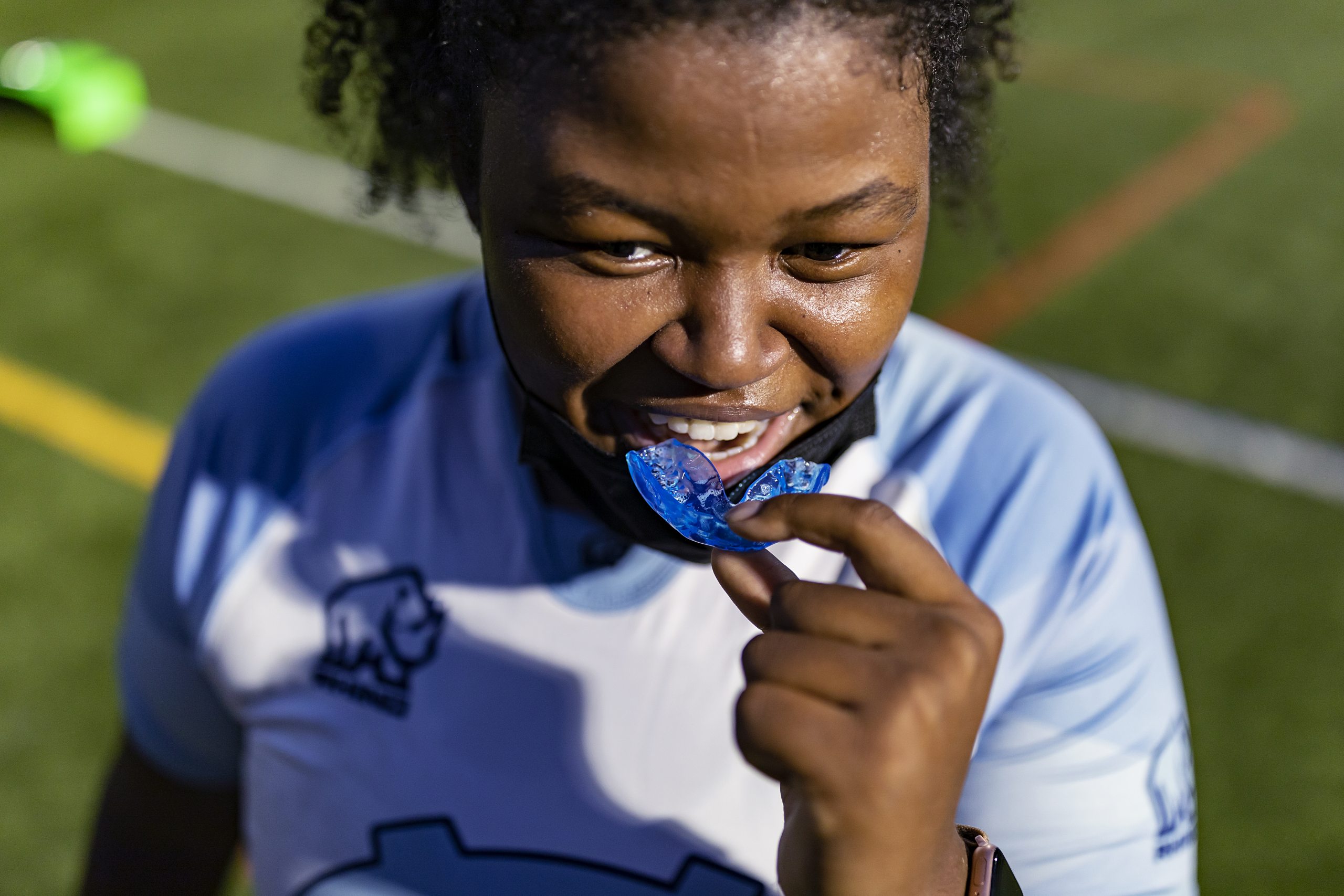 A player puts a mouth guard in her mouth.