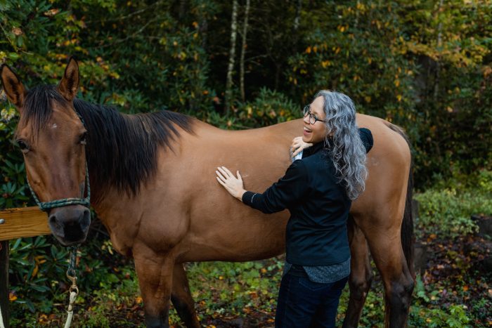 A woman petting a horse. 