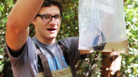 A student with a salamander in a bag.