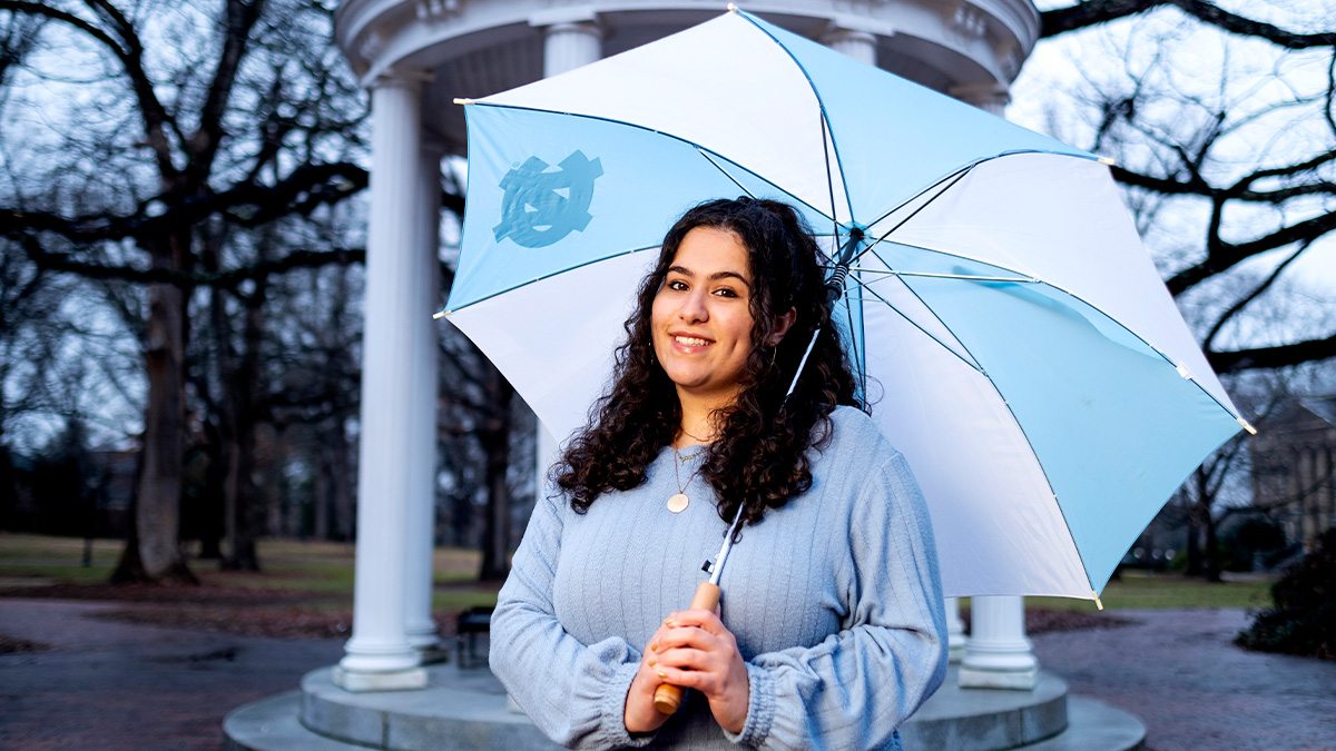 Dalal Azzam holds an umbrella by the Old Well.