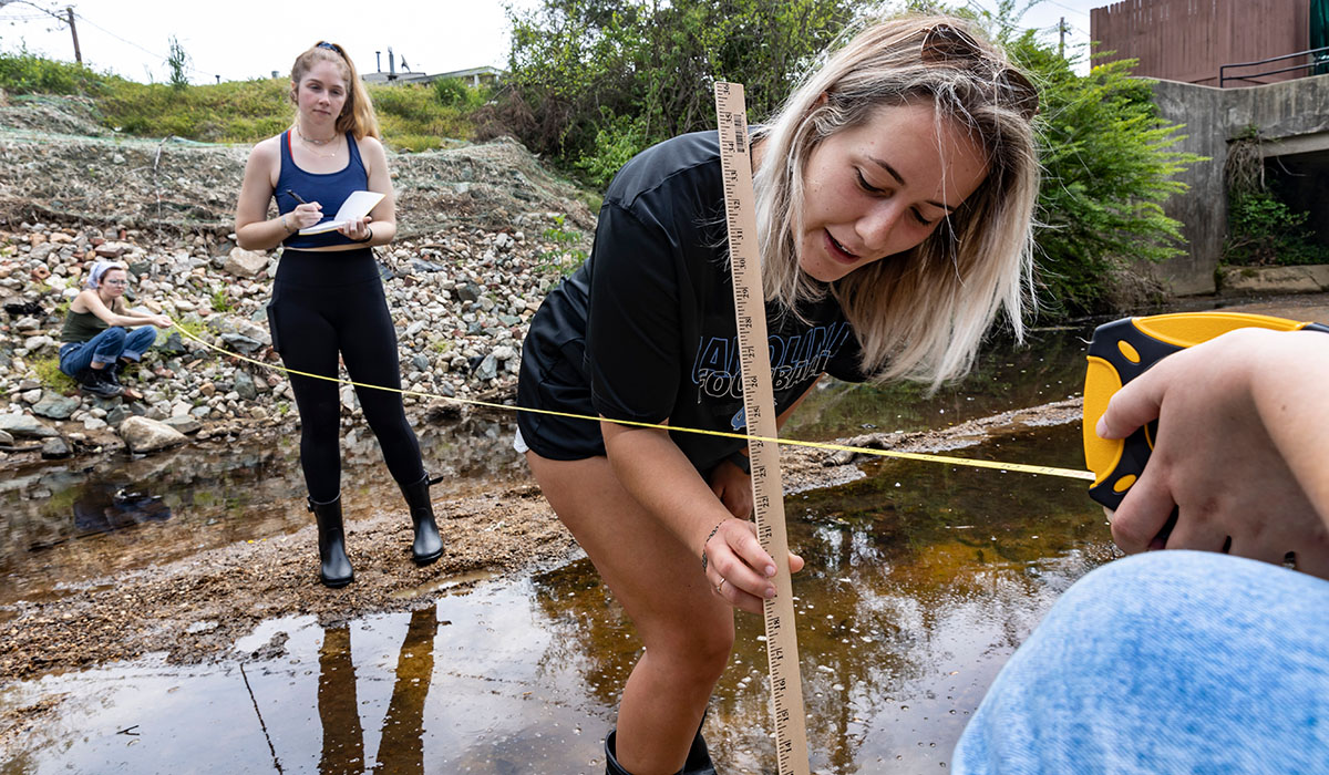 A student measures water depth