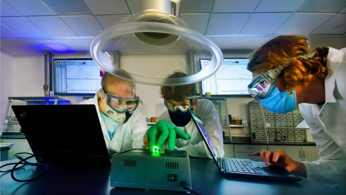 Three people working in a lab.