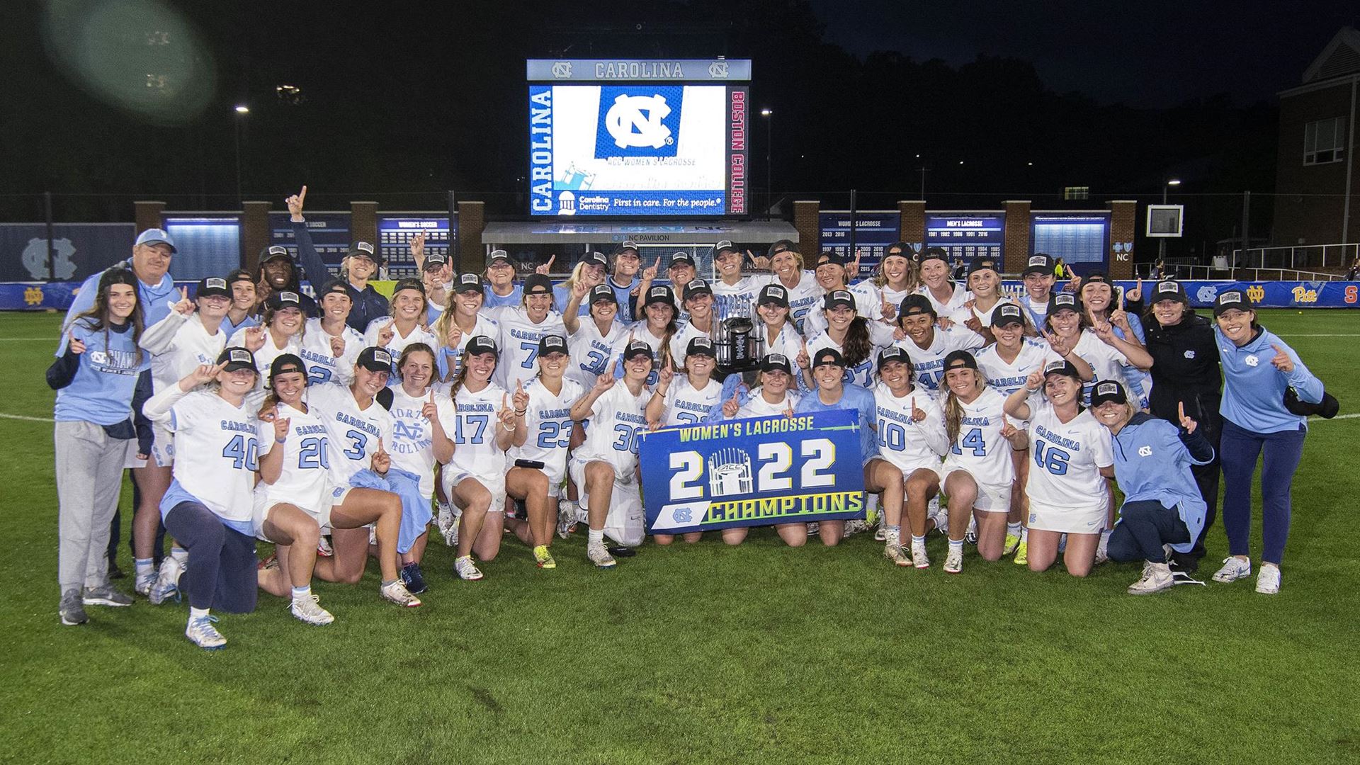 Women's lacrosse team poses with an ACC Championship sign