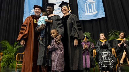 A family poses for a photo at doctoral hooding.
