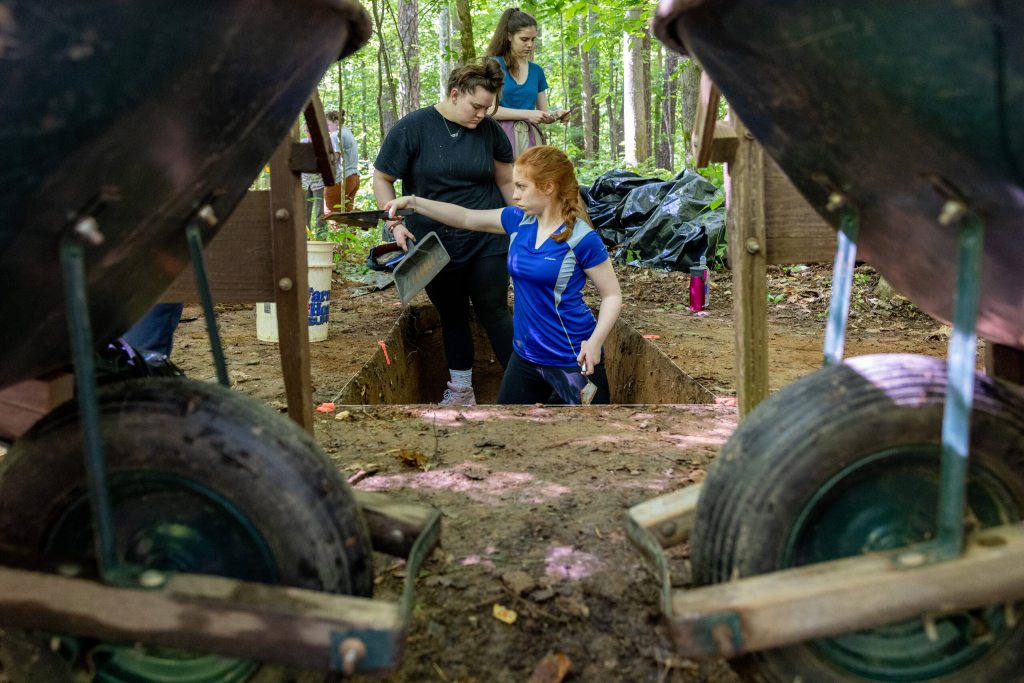Maria Reid and Caroline Maness clear loose dirt out of a test unit during an excavation at the Duke Forest site.