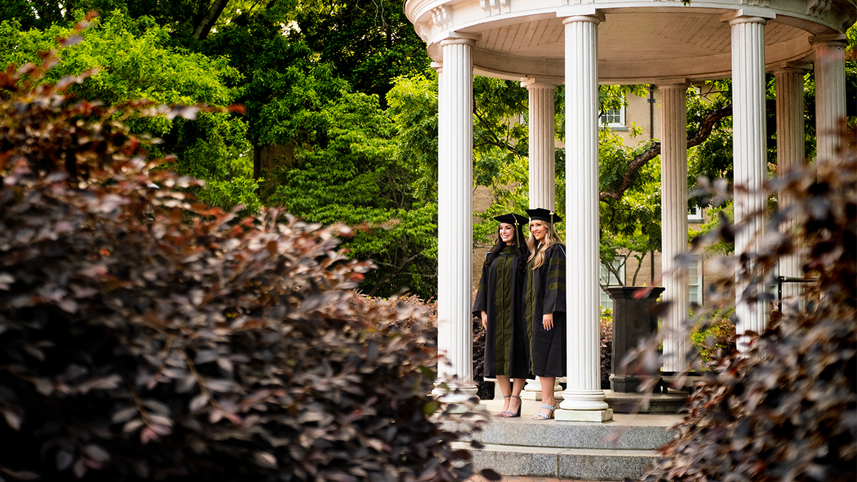 Graduating students take photos at the Old Well.